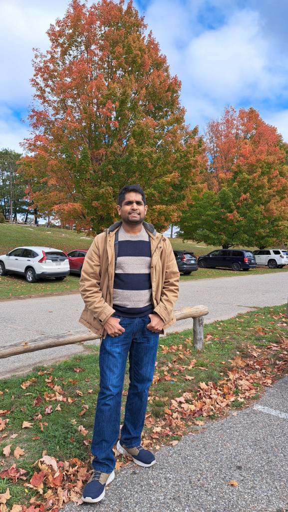 Adrian Peries with autumn trees in the background.